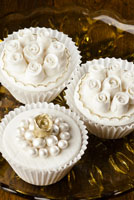 Fondant covered cupcakes with small gumpaste roses and pearls.